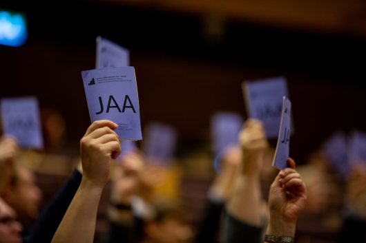 Käsiäänestyksessä ylös nostettuja äänestyslippuja / Voting tickets raised in peoples hands